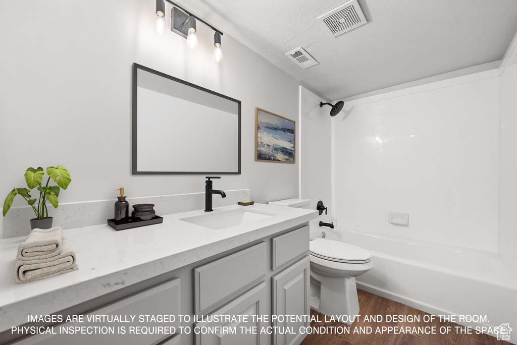 Full bathroom featuring vanity, bathing tub / shower combination, a textured ceiling, and toilet