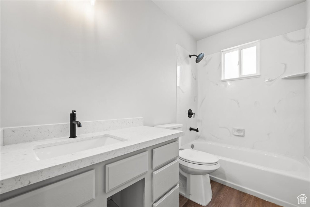 Full bathroom with wood-type flooring, bathtub / shower combination, toilet, and vanity