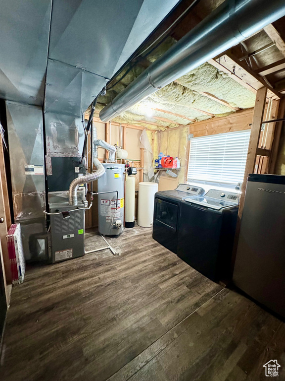 Basement featuring dark hardwood / wood-style flooring, separate washer and dryer, gas water heater, and heating utilities