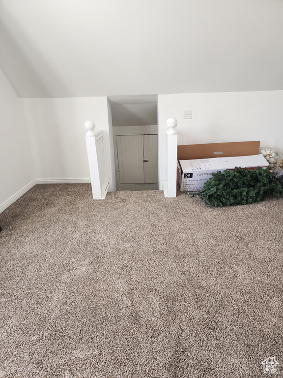 Interior space featuring vaulted ceiling and carpet flooring