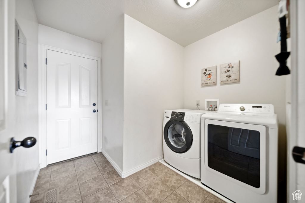 Laundry area featuring washer hookup, washing machine and dryer, and light tile floors