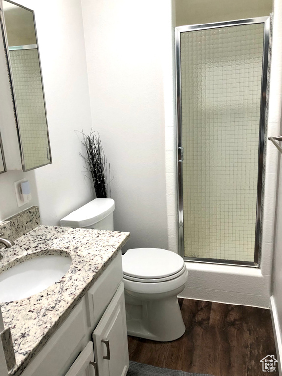Bathroom featuring hardwood / wood-style flooring, toilet, and large vanity