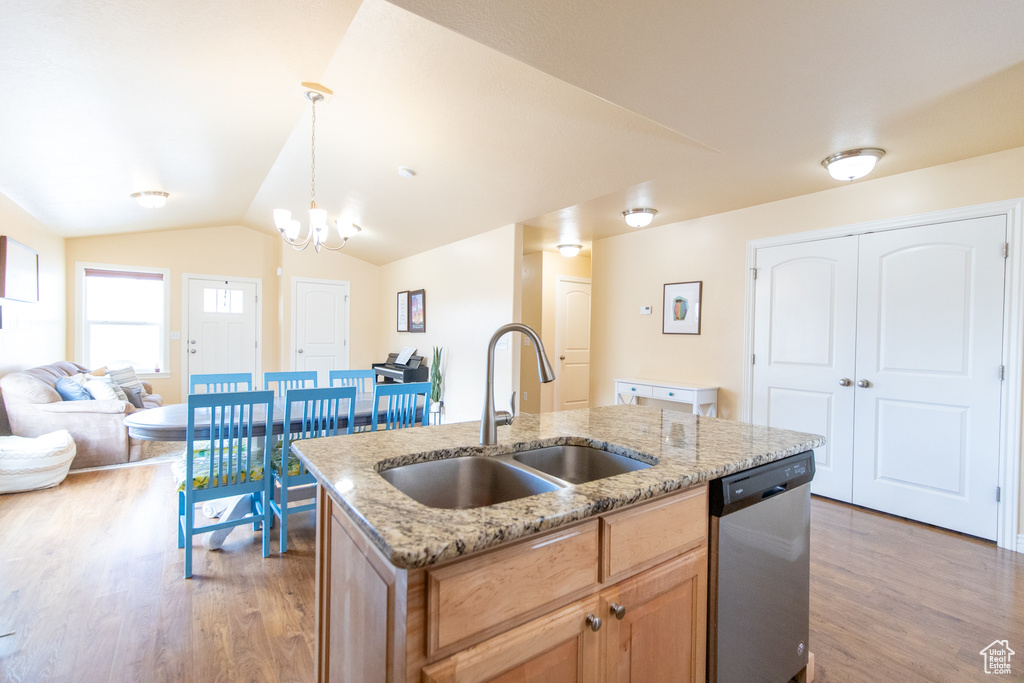 Kitchen featuring sink, a chandelier, hanging light fixtures, an island with sink, and dishwasher
