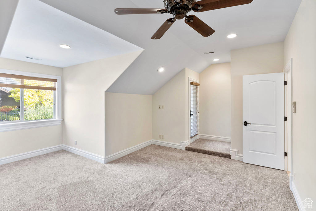 Bonus room featuring ceiling fan, light carpet, and vaulted ceiling