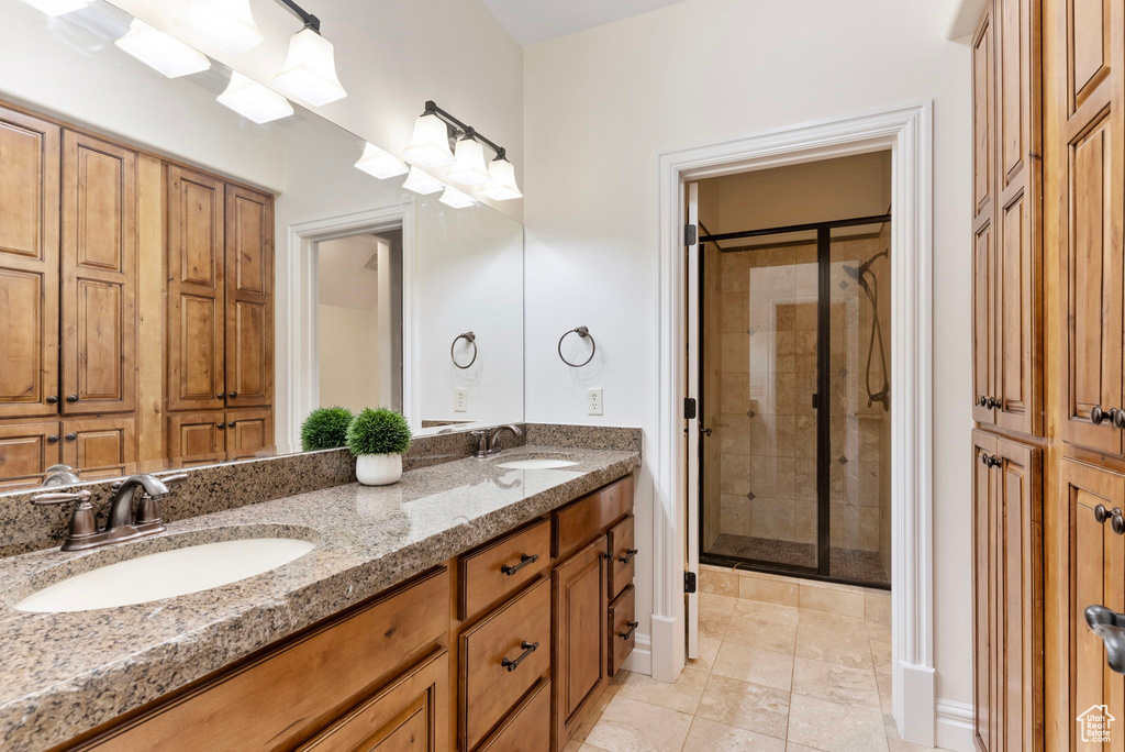 Bathroom featuring vanity, tile patterned flooring, and a shower with shower door