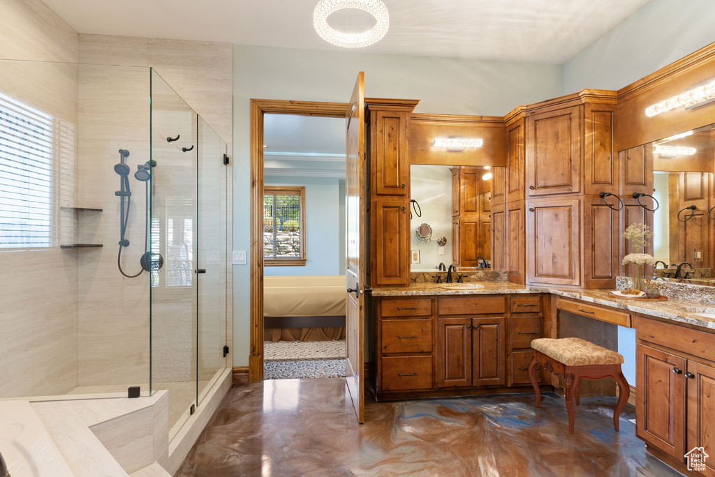 Bathroom featuring walk in shower and vanity with extensive cabinet space