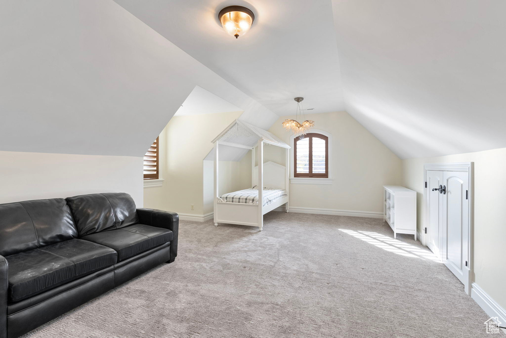 Carpeted bedroom featuring an inviting chandelier and lofted ceiling