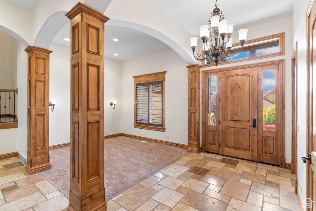 Entryway with a notable chandelier and ornate columns