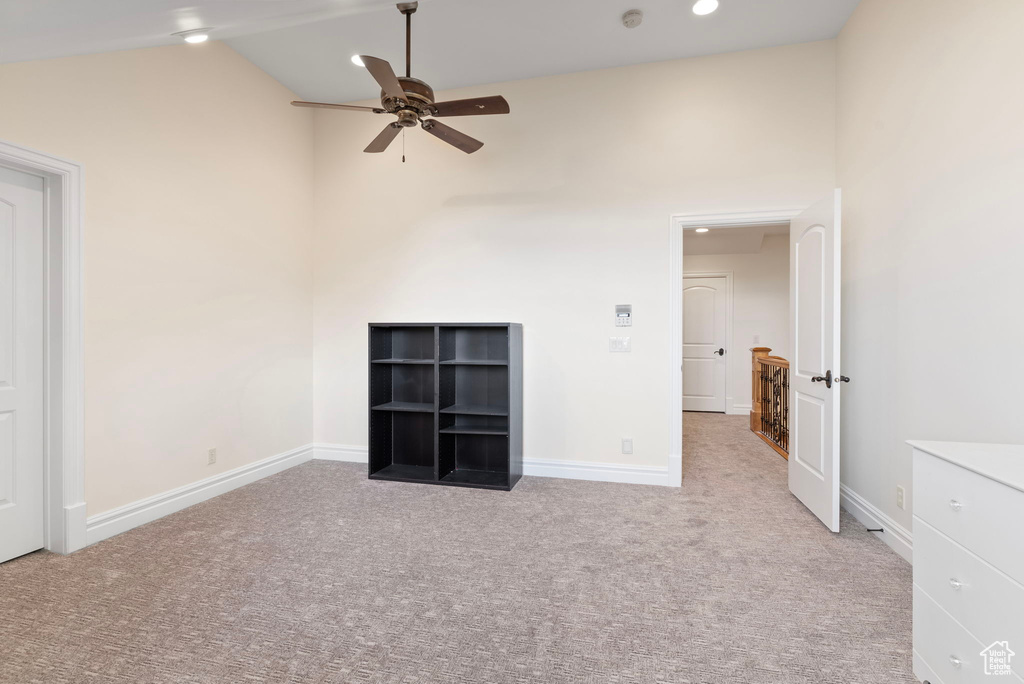 Unfurnished room featuring high vaulted ceiling, light colored carpet, and ceiling fan