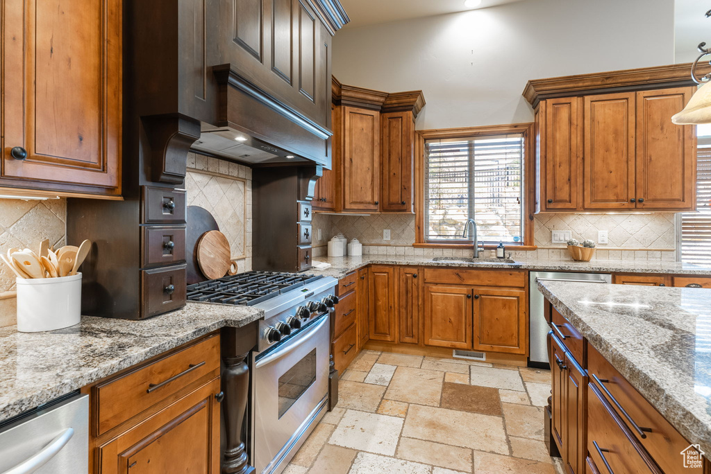 Kitchen with range with gas cooktop, sink, decorative light fixtures, backsplash, and dishwasher