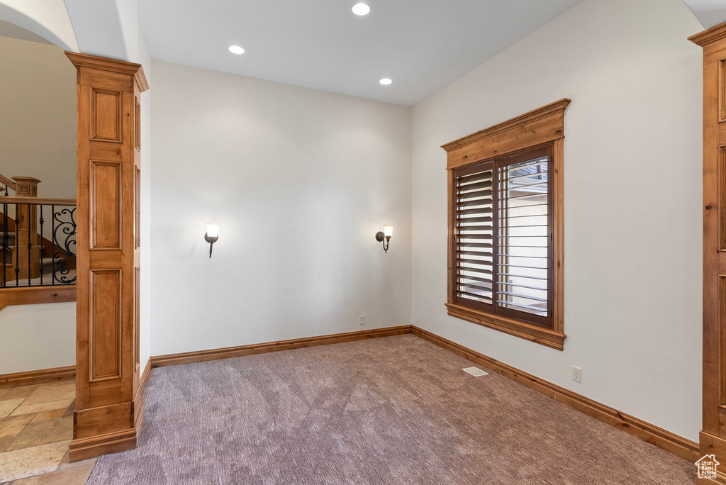 Unfurnished room featuring light carpet and ornate columns