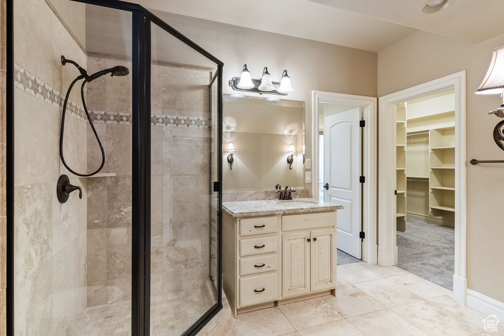 Bathroom with an enclosed shower, oversized vanity, and tile flooring