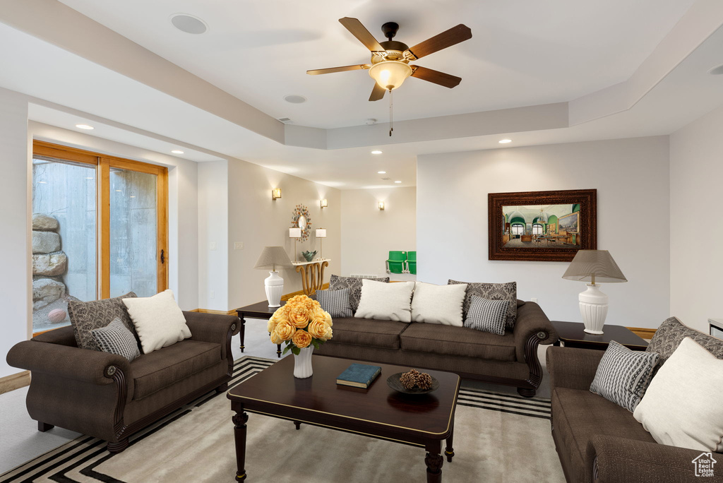 Living room featuring ceiling fan and a raised ceiling