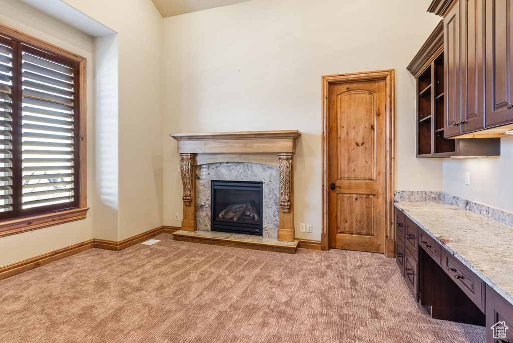 Interior space featuring a premium fireplace and light carpet
