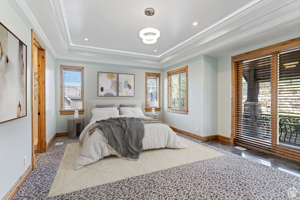 Bedroom with ornamental molding, carpet floors, and a tray ceiling