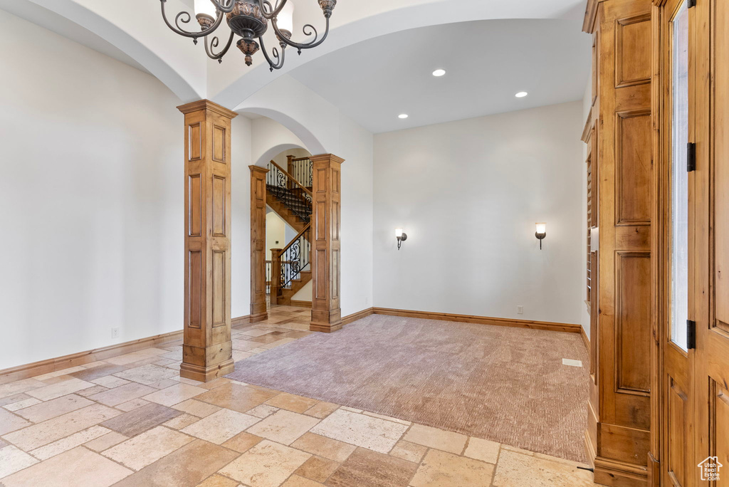 Spare room featuring a notable chandelier and decorative columns