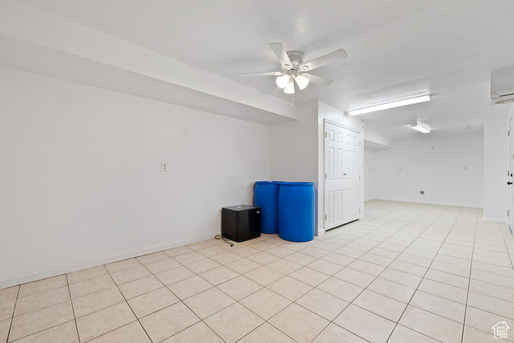 Empty room featuring light tile floors and ceiling fan