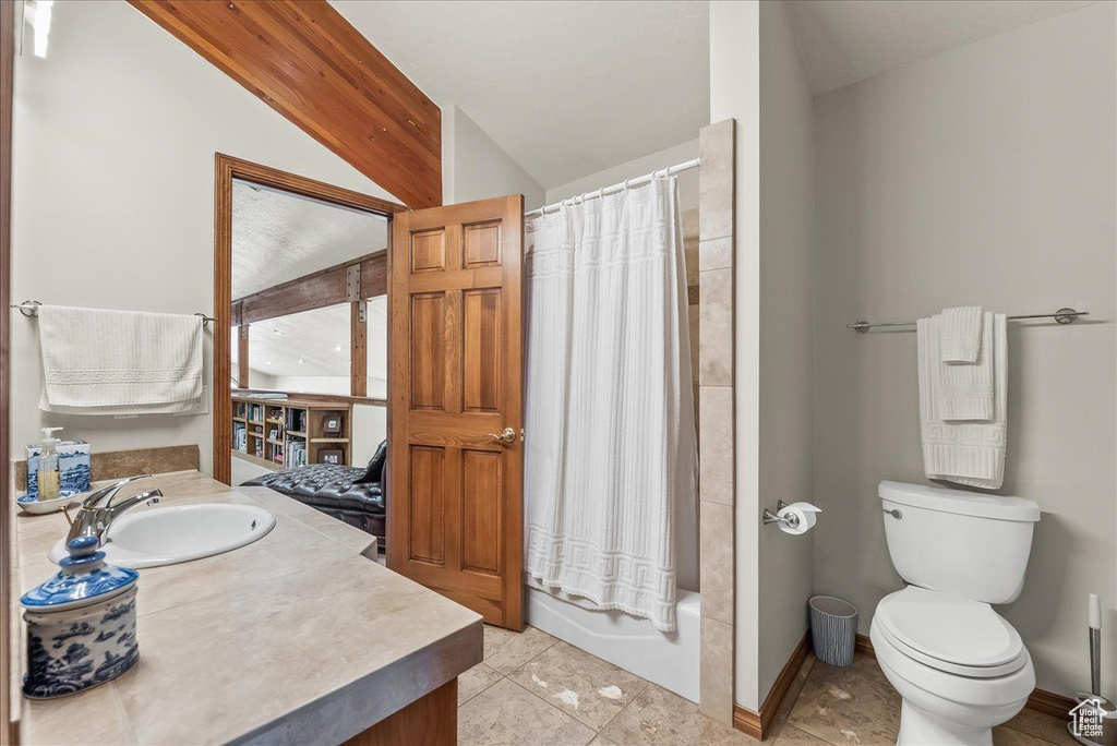 Full bathroom featuring shower / bathtub combination with curtain, tile floors, vanity, lofted ceiling, and toilet
