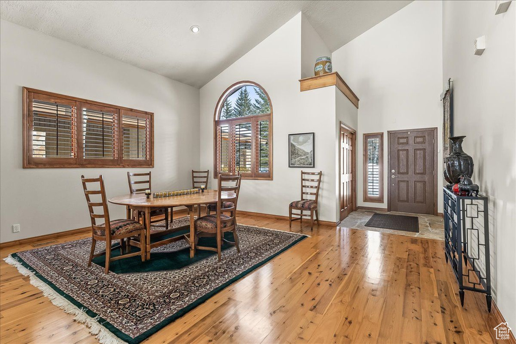 Dining room featuring light hardwood / wood-style floors and high vaulted ceiling