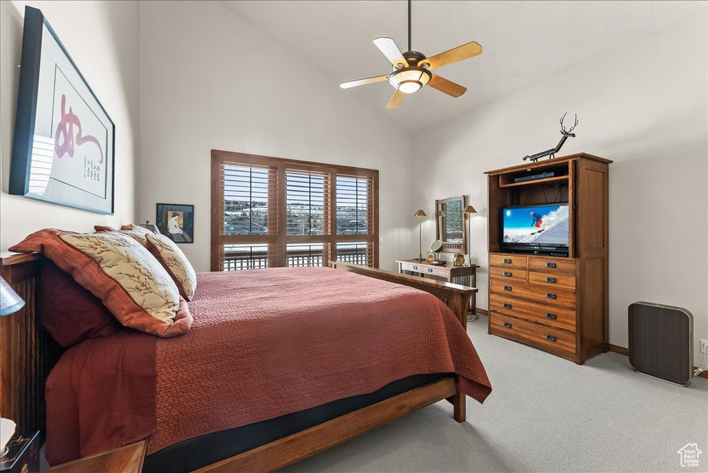 Bedroom featuring high vaulted ceiling, light carpet, and ceiling fan