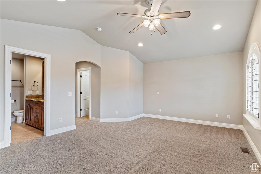 Interior space featuring light carpet, lofted ceiling, and ceiling fan