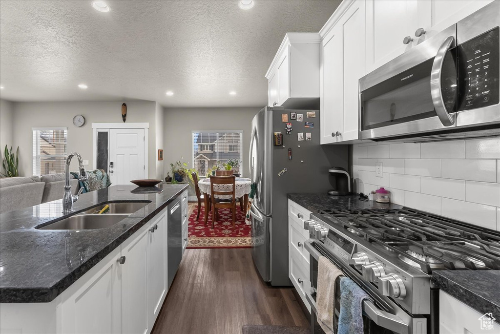 Kitchen featuring appliances with stainless steel finishes, plenty of natural light, dark hardwood / wood-style flooring, and sink