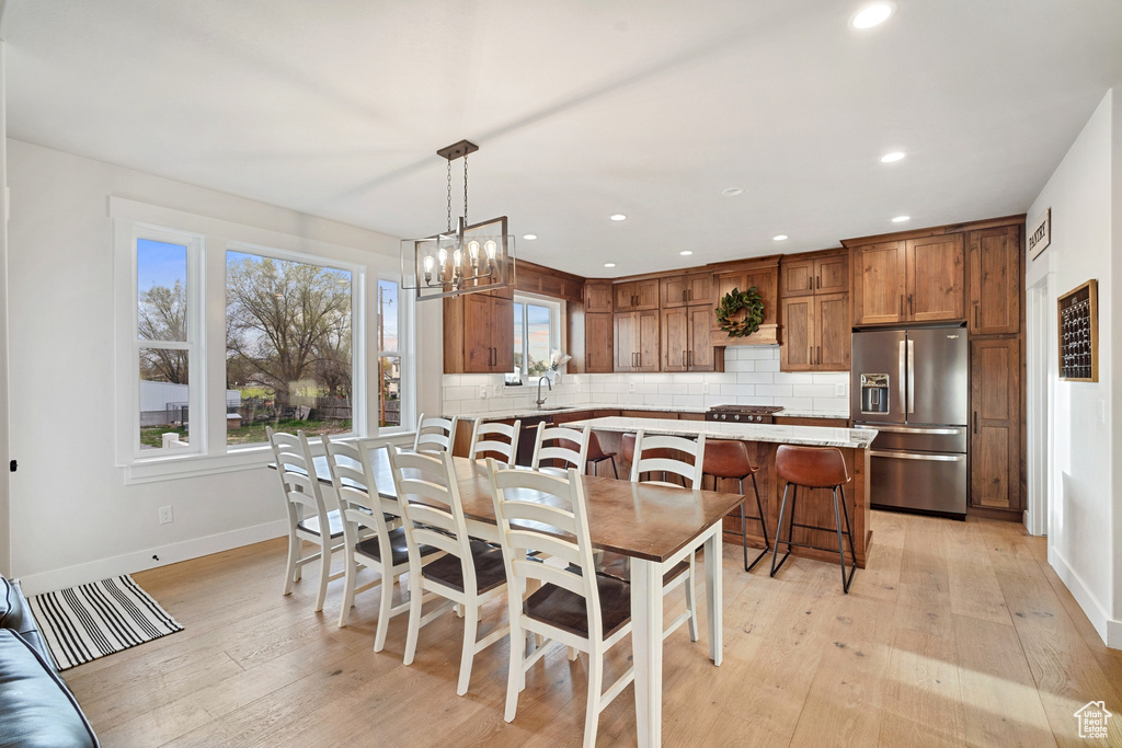 Dining area featuring light hardwood / wood-style flooring, sink, and an inviting chandelier