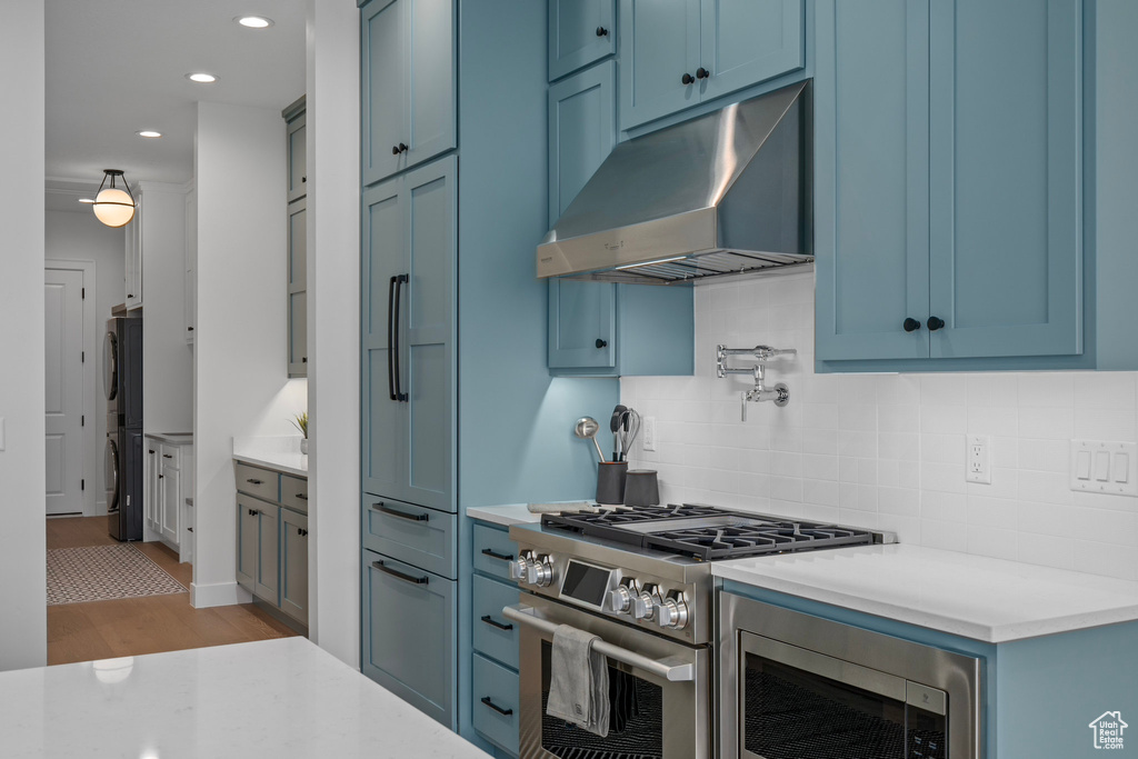 Kitchen with backsplash, stainless steel appliances, and light hardwood / wood-style floors