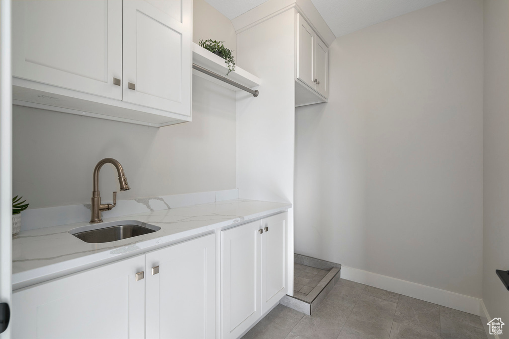 Laundry room featuring light tile floors and sink