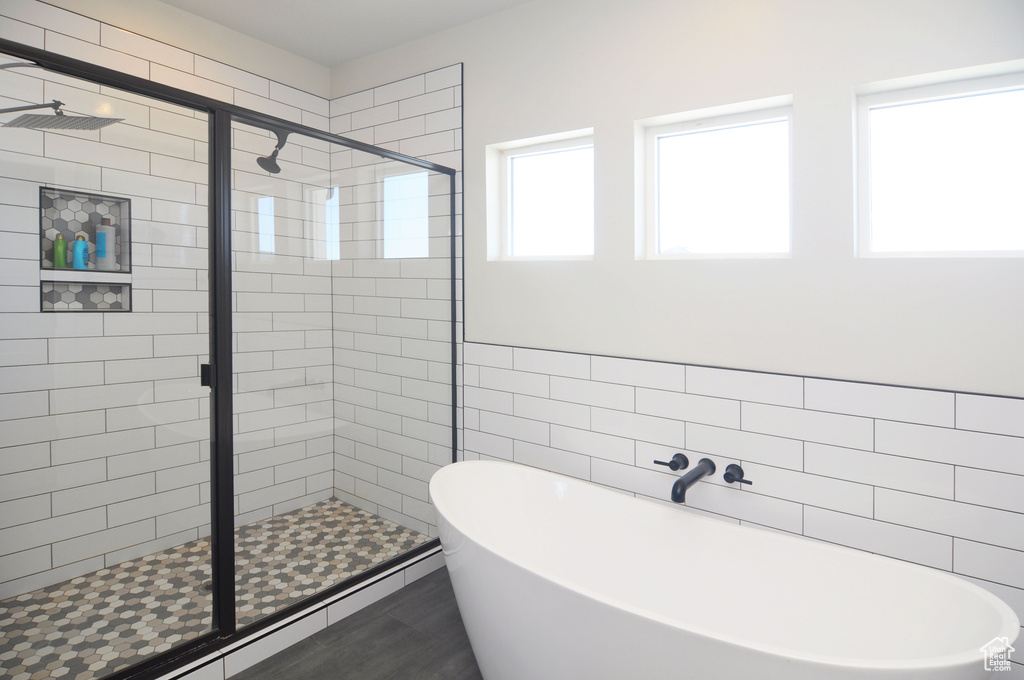 Bathroom featuring a shower with shower door, tile flooring, and tile walls