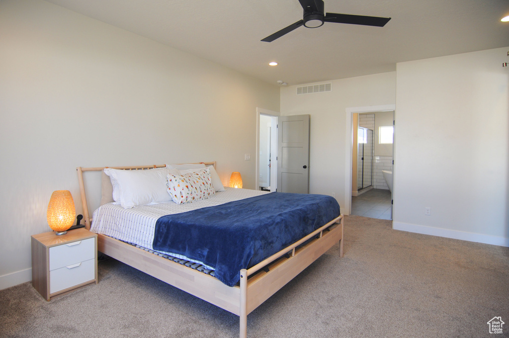 Bedroom featuring light carpet, ensuite bathroom, and ceiling fan