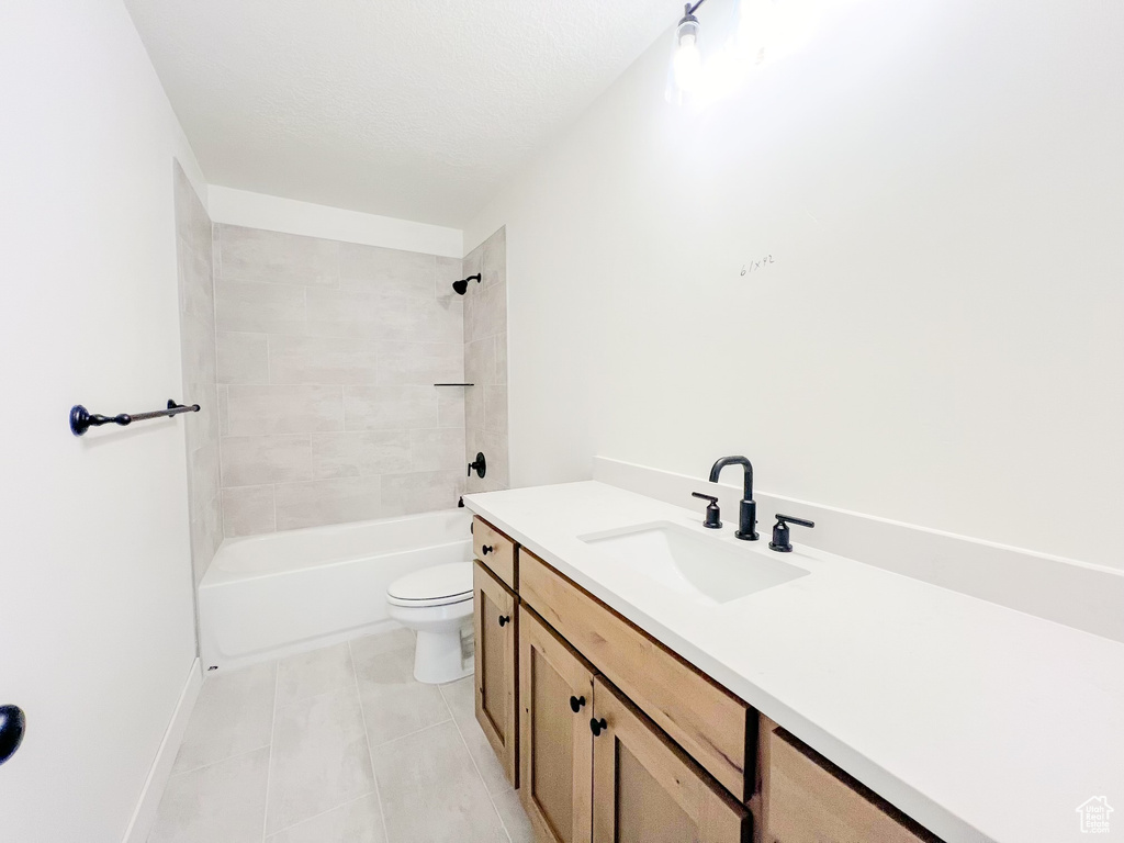 Full bathroom featuring tile flooring, tiled shower / bath combo, toilet, and vanity
