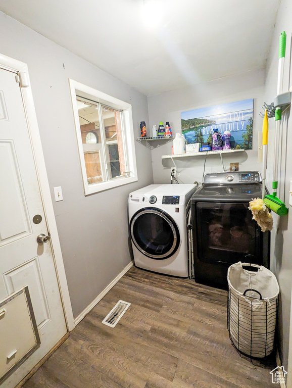 Clothes washing area featuring dark hardwood / wood-style flooring, hookup for a washing machine, and washer and dryer