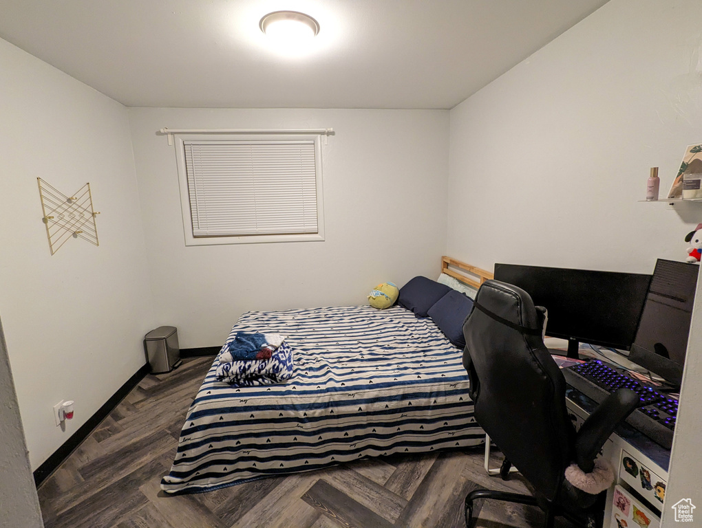 Bedroom with dark parquet flooring