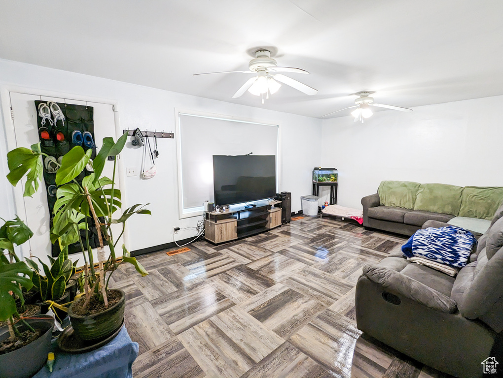 Living room featuring ceiling fan and light parquet flooring
