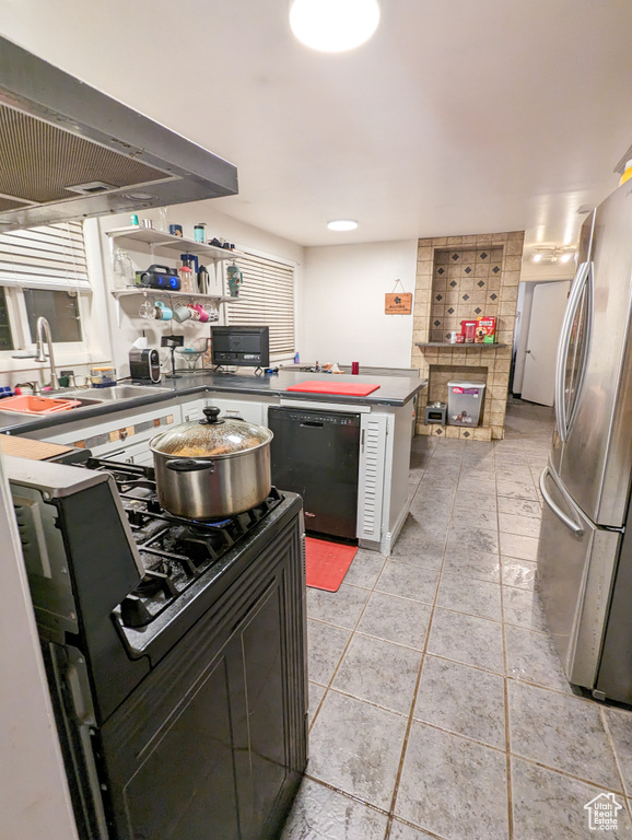 Kitchen featuring sink, stainless steel fridge, range, dishwasher, and light tile floors