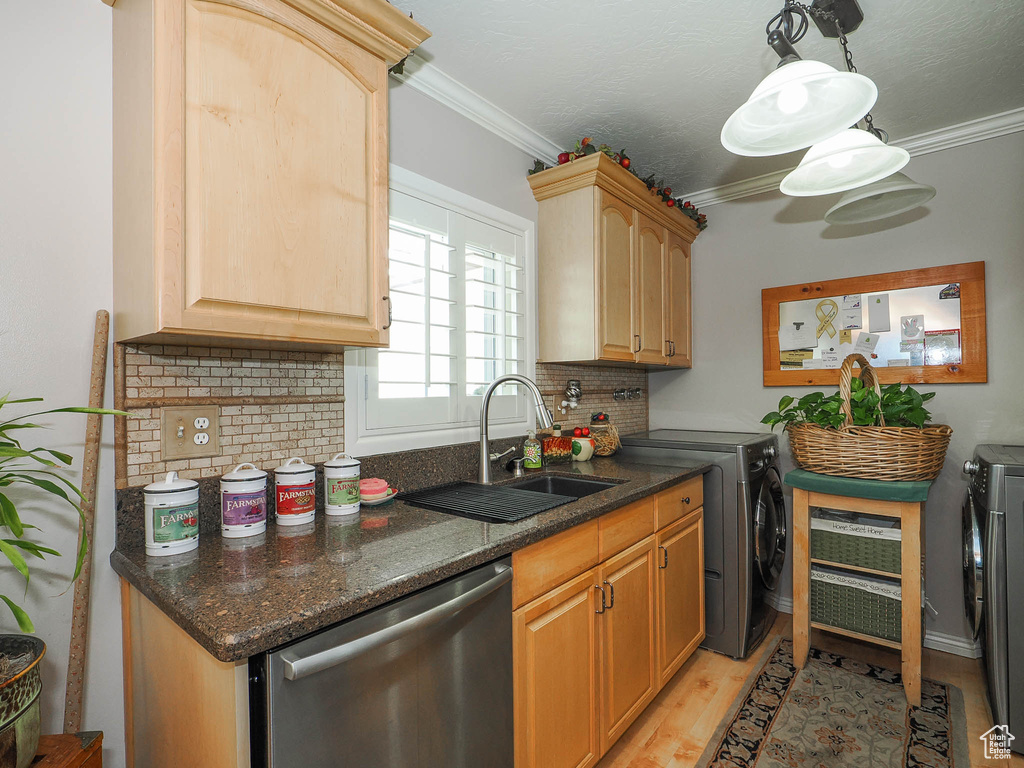 Kitchen featuring light hardwood / wood-style flooring, backsplash, ornamental molding, separate washer and dryer, and stainless steel dishwasher