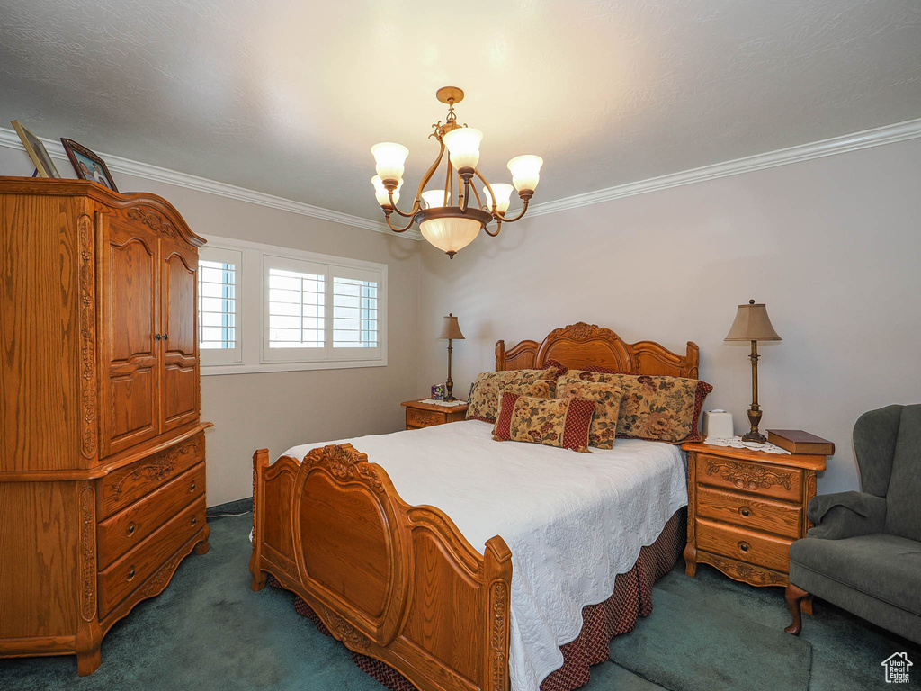 Carpeted bedroom with ornamental molding and a notable chandelier