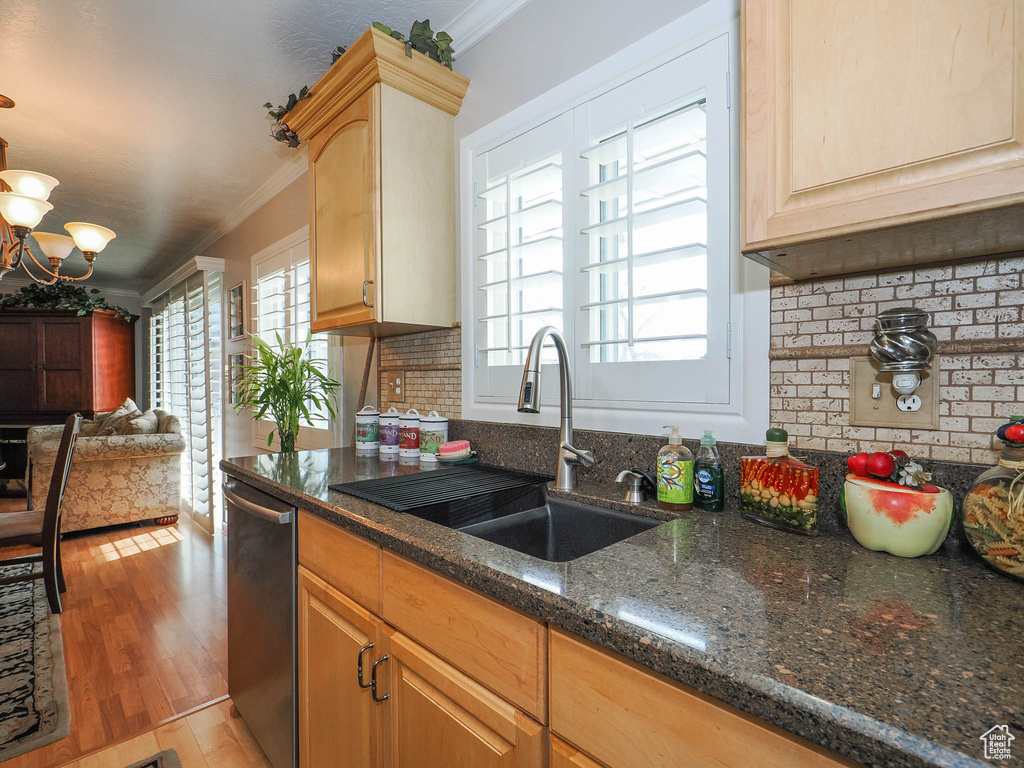 Kitchen featuring light hardwood / wood-style floors, dishwasher, crown molding, a notable chandelier, and sink