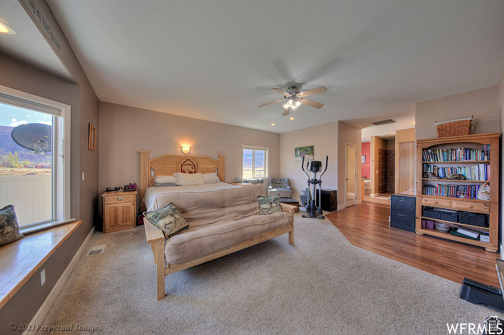 Bedroom with access to exterior, ceiling fan, and light hardwood / wood-style floors