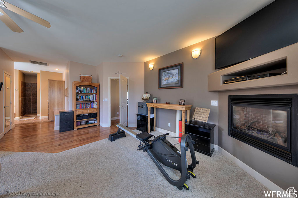 Workout area featuring light hardwood / wood-style flooring and ceiling fan