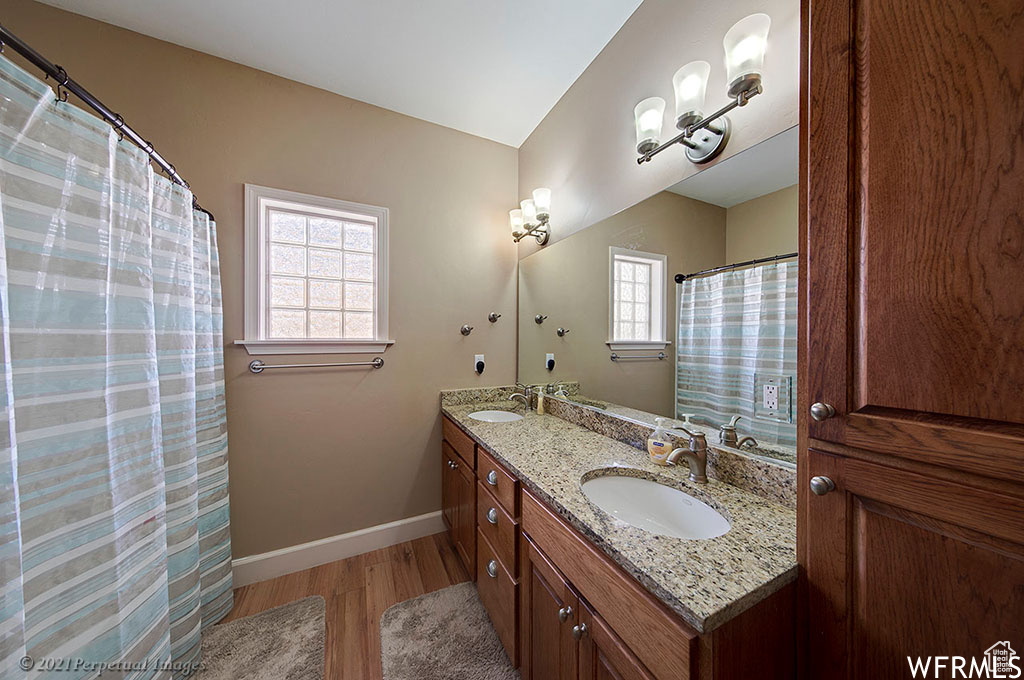 Bathroom featuring dual vanity and hardwood / wood-style floors