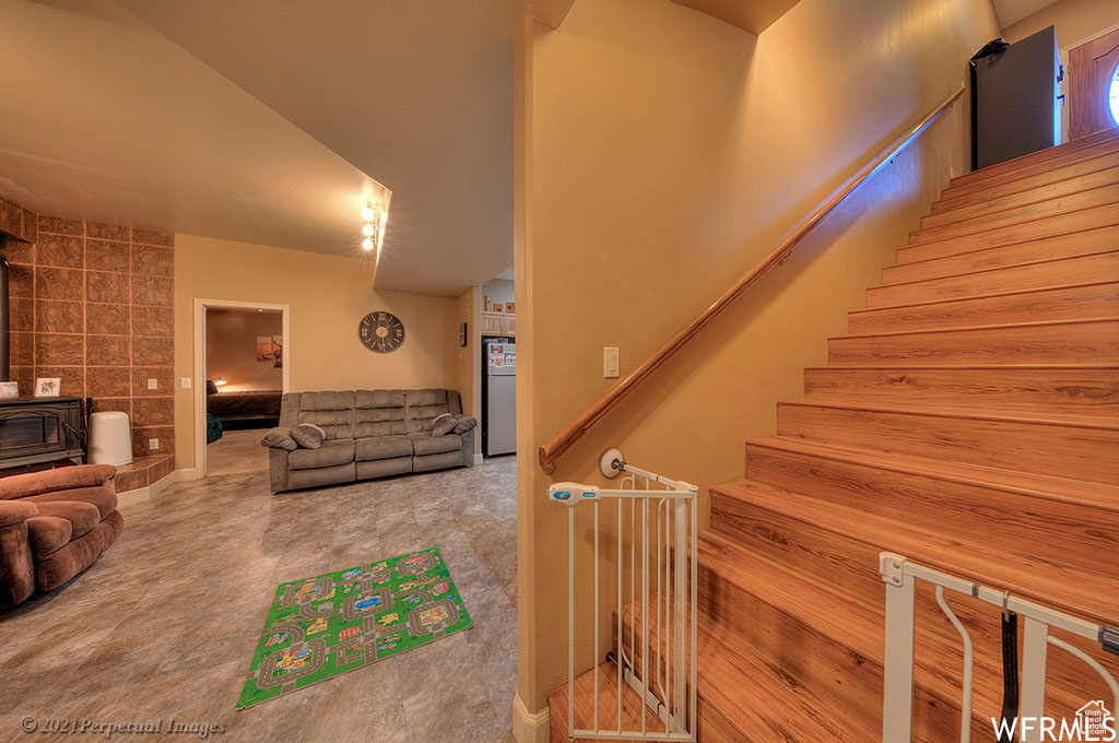 Stairs with light colored carpet and a wood stove