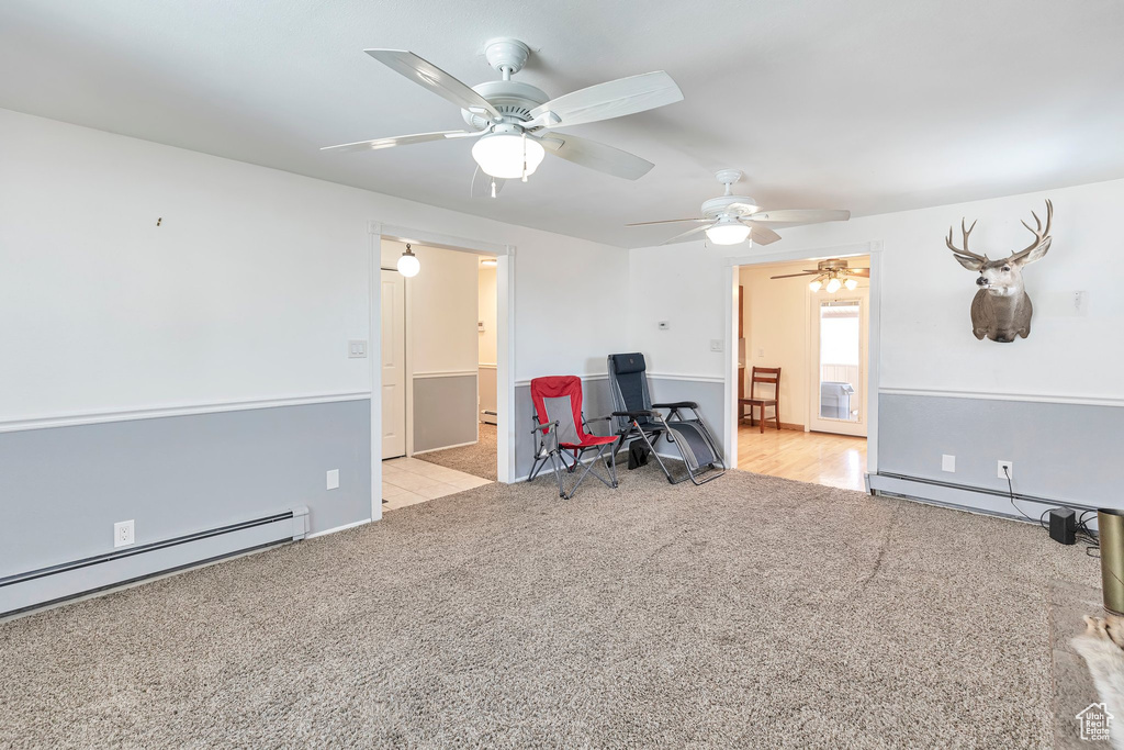 Unfurnished office featuring light colored carpet, a baseboard heating unit, and ceiling fan