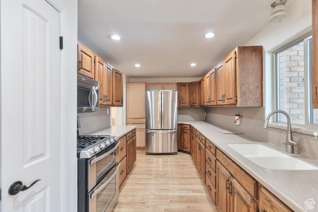 Kitchen featuring appliances with stainless steel finishes, light wood-type flooring, and sink