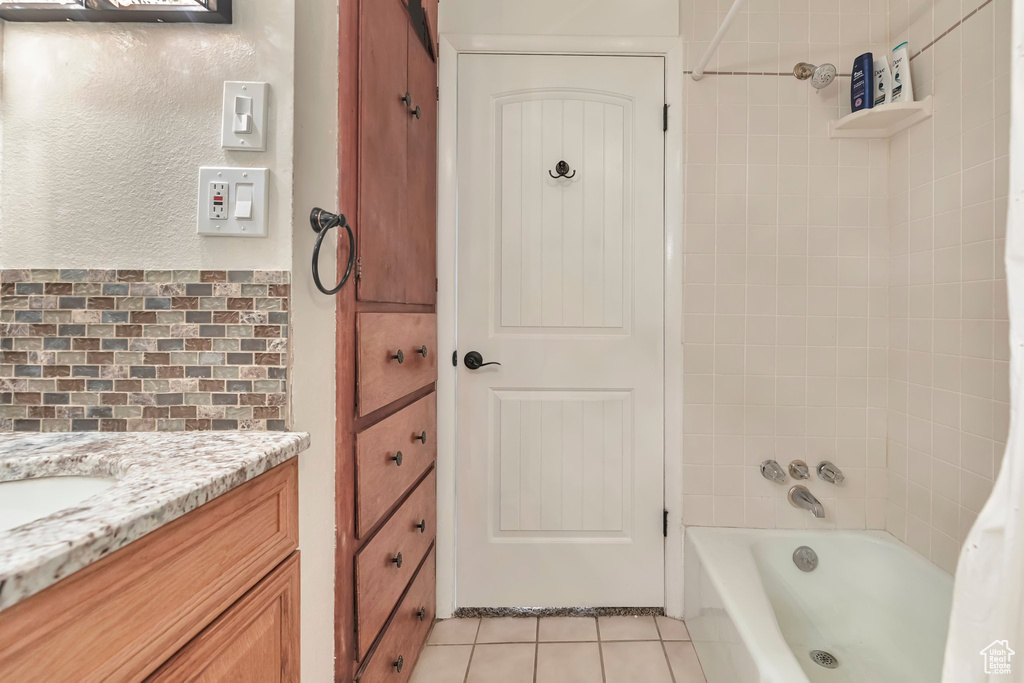 Bathroom with vanity, tasteful backsplash, tile floors, and shower / bathtub combination with curtain