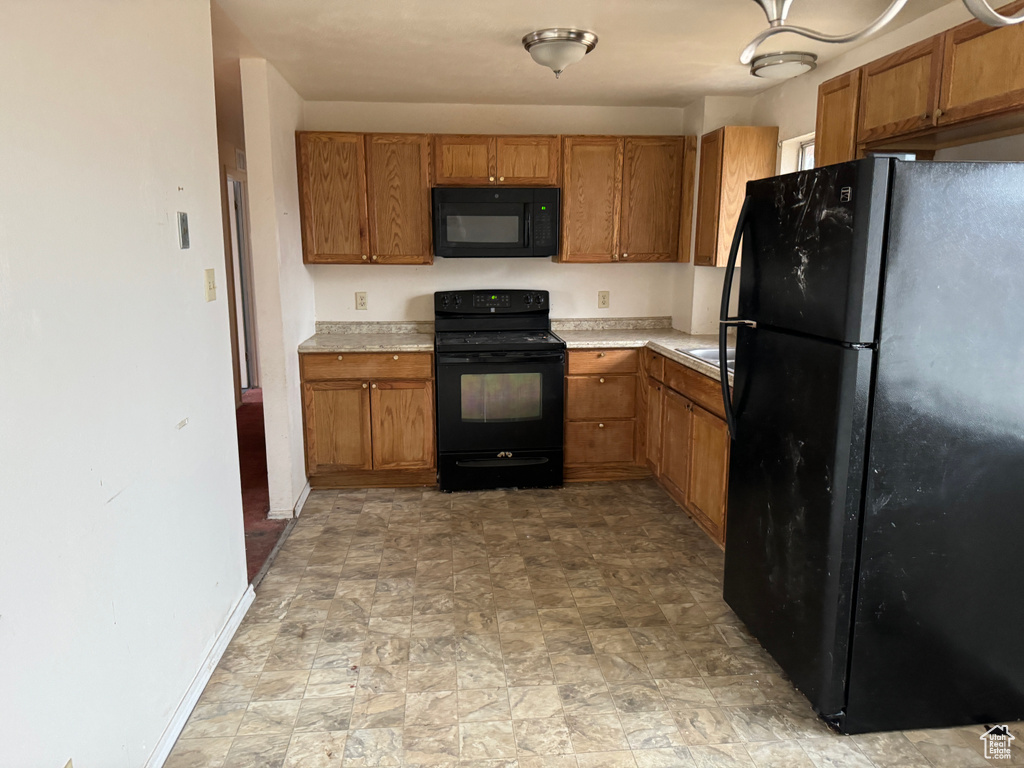 Kitchen with black appliances and light tile floors