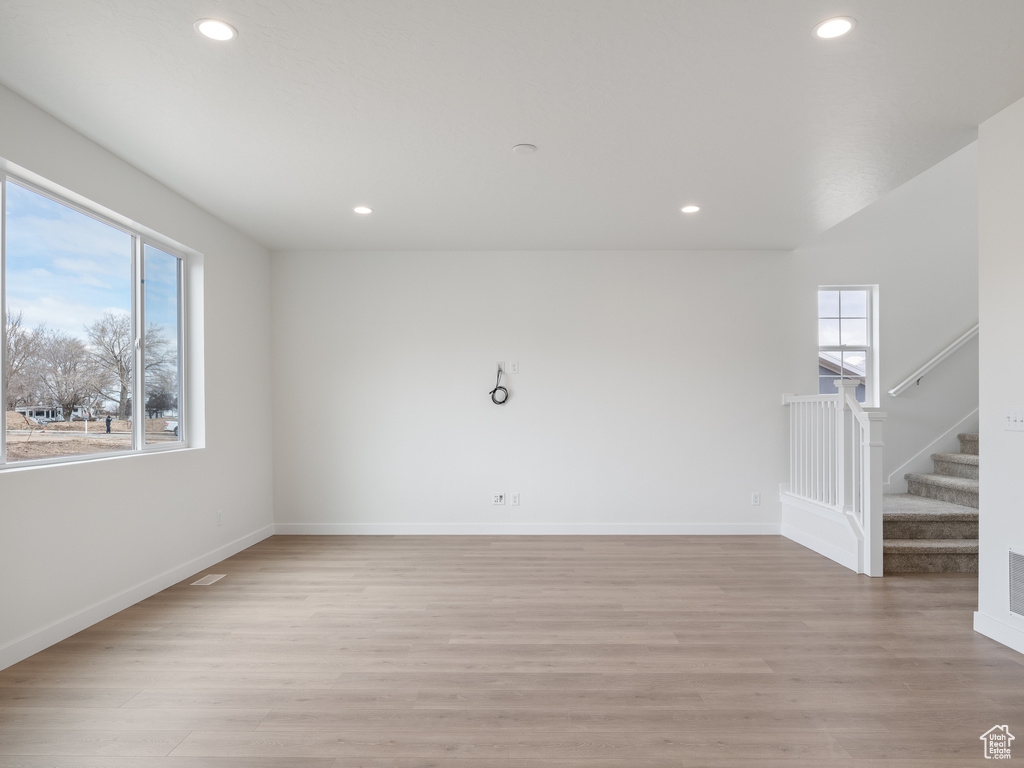 Empty room with a healthy amount of sunlight and light hardwood / wood-style flooring