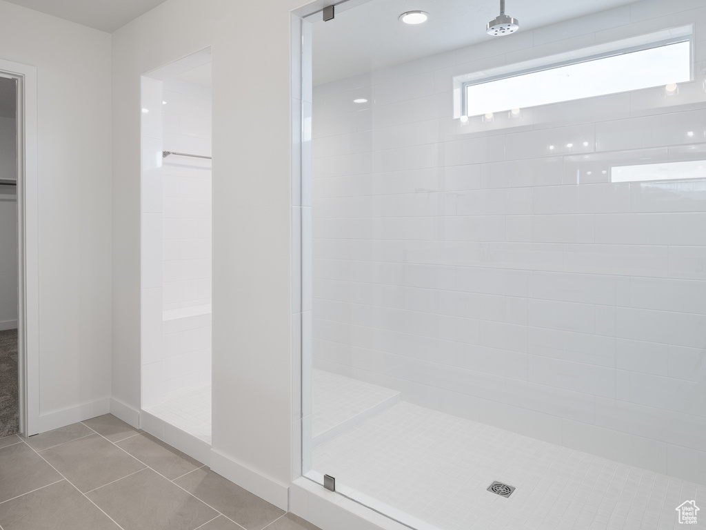 Bathroom featuring tiled shower and tile flooring