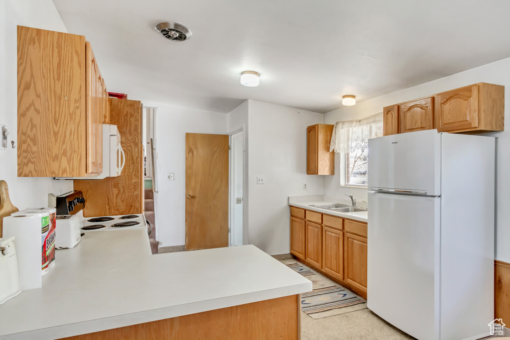 Kitchen featuring range, white refrigerator, and sink
